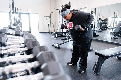 A Indigenous woman working out in a gym