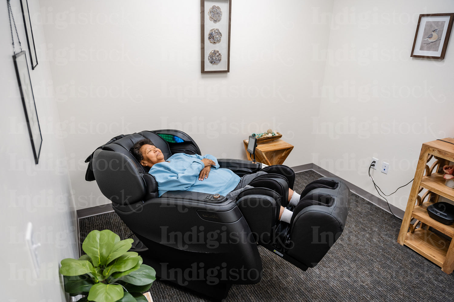 Native Elder relaxing in message chair at health center