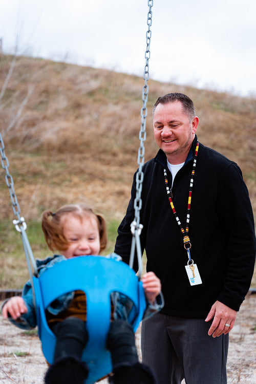 A father pushing his daughter on a swing