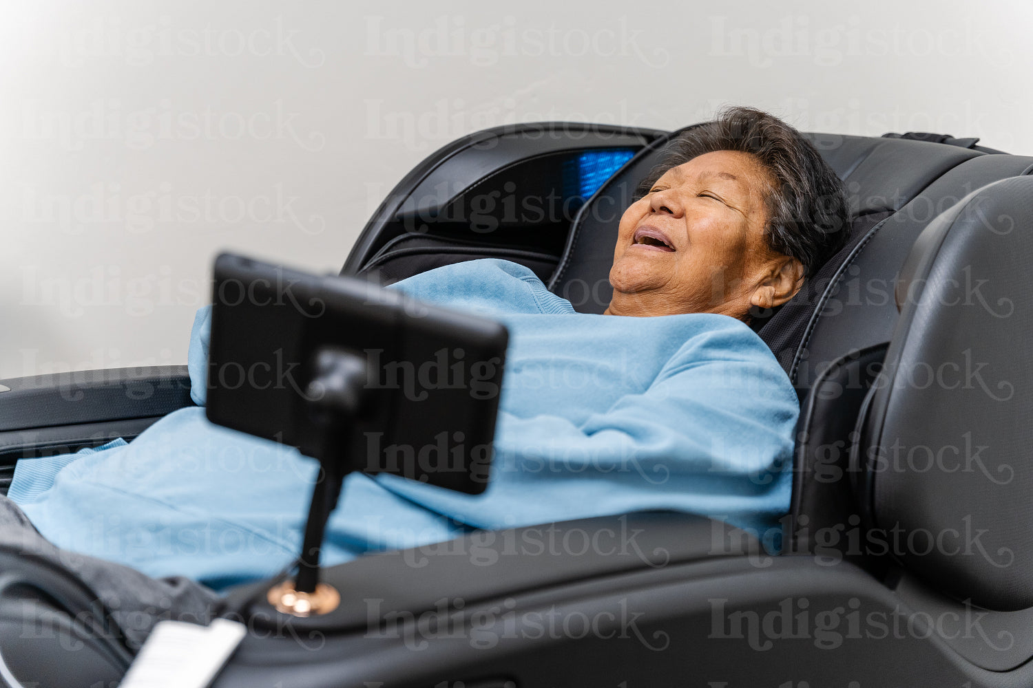 Native Elder relaxing in message chair at health center