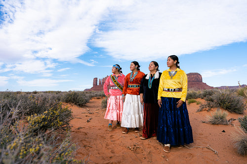 An indigenous family wearing traditional regalia outside