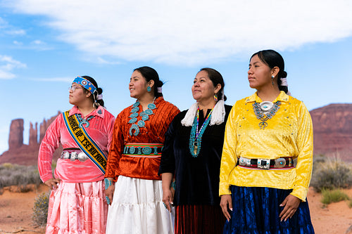 An indigenous family wearing traditional regalia outside