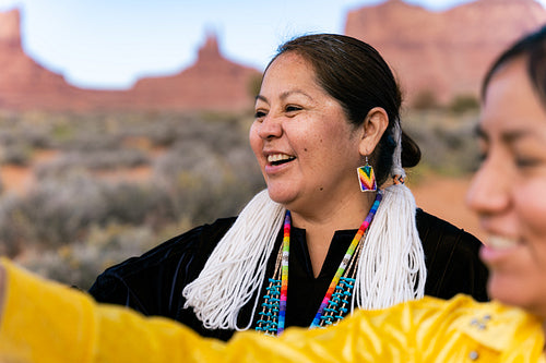 An indigenous family wearing traditional regalia outside