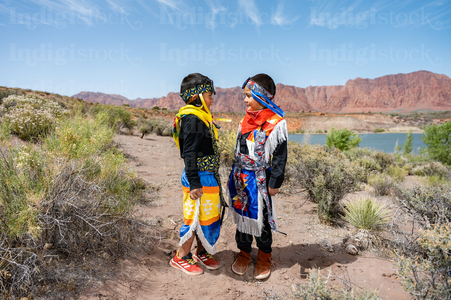 Two young Native American boys wearing traditional regalia outsi