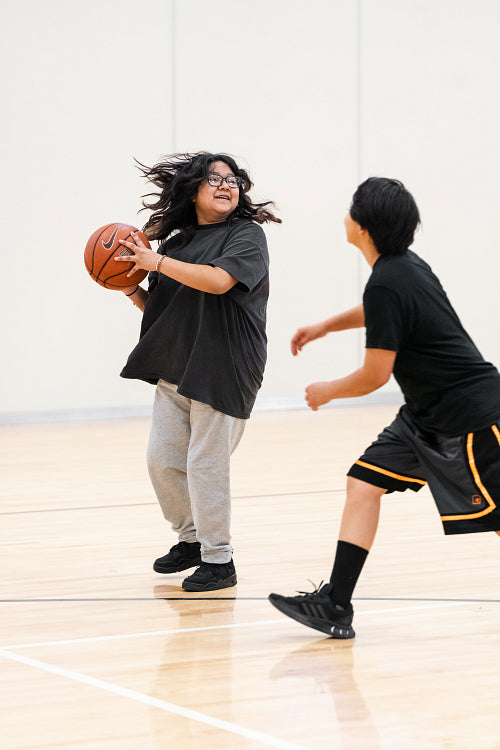 Native youth playing basketball