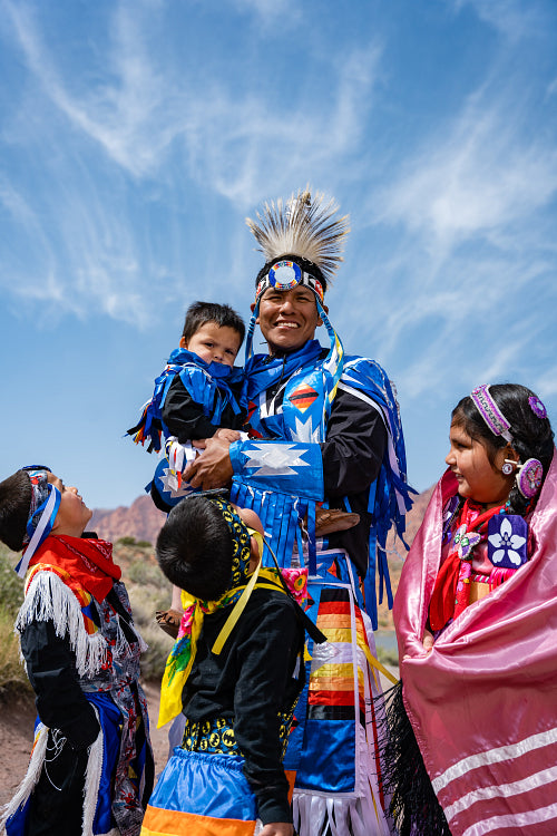 Happy Indigenous family in tradtional regalia outside