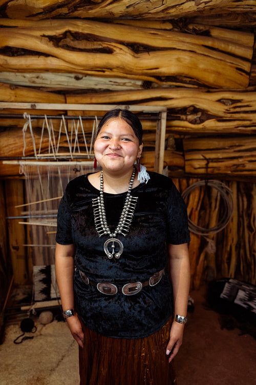 A Native American Navajo woman standing inside a Hogan Earthlodg